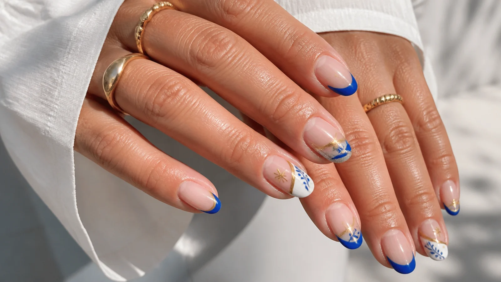 Royal blue french tips paired with gold, silver, white and nude accents