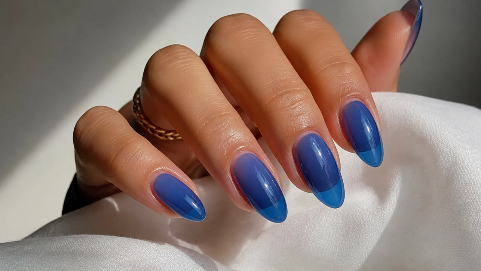 Sheer royal blue jelly nails with a translucent glassy finish