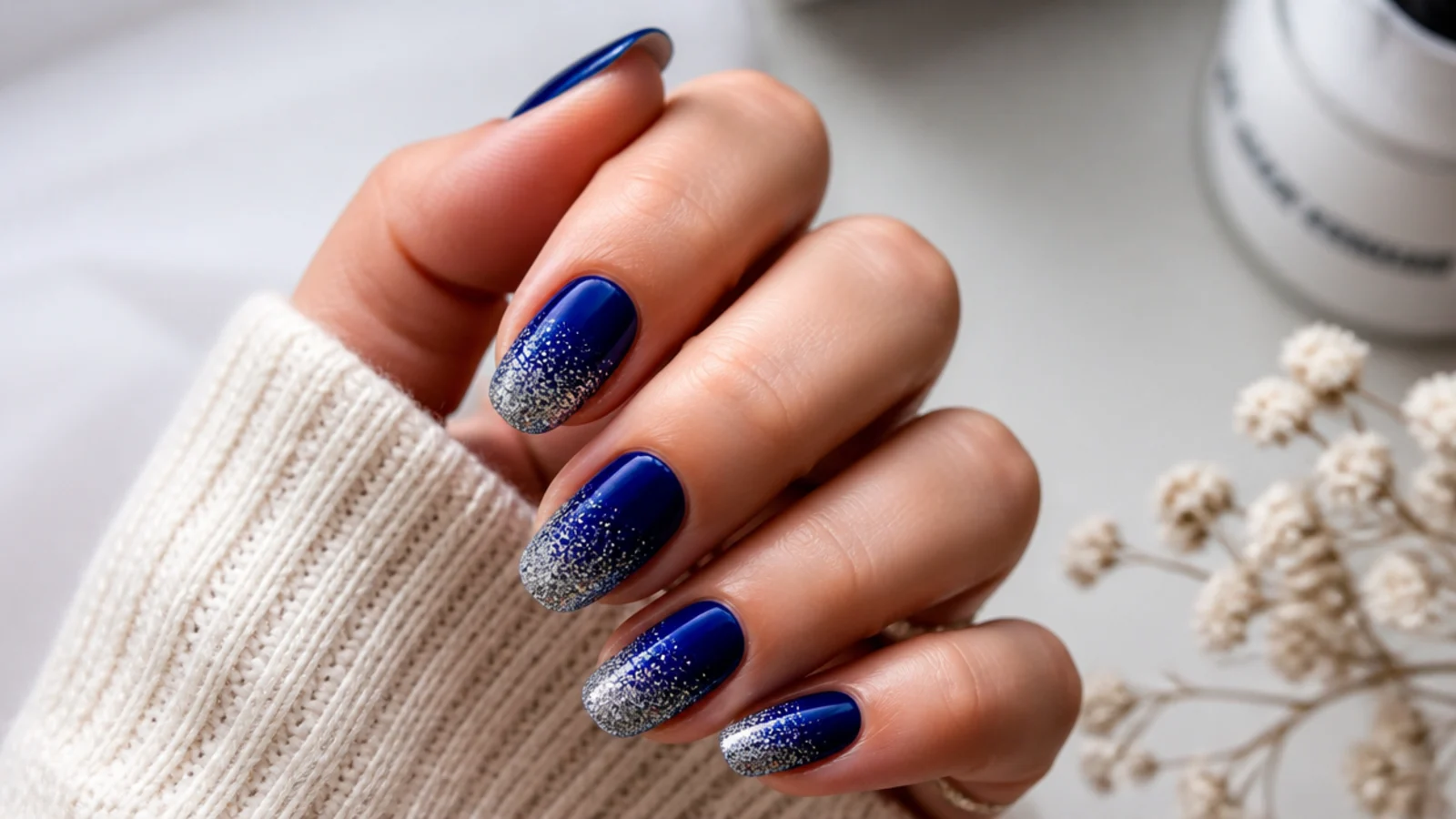 Royal blue nails fading into silver glitter at the tips