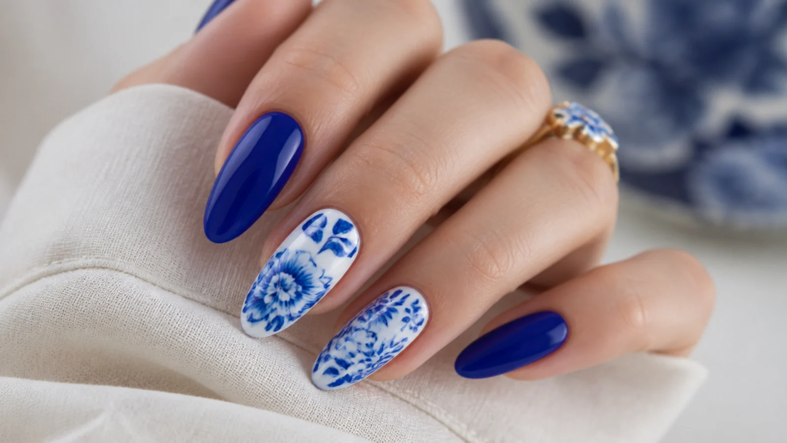 Royal blue nails with delicate white porcelain-style floral art