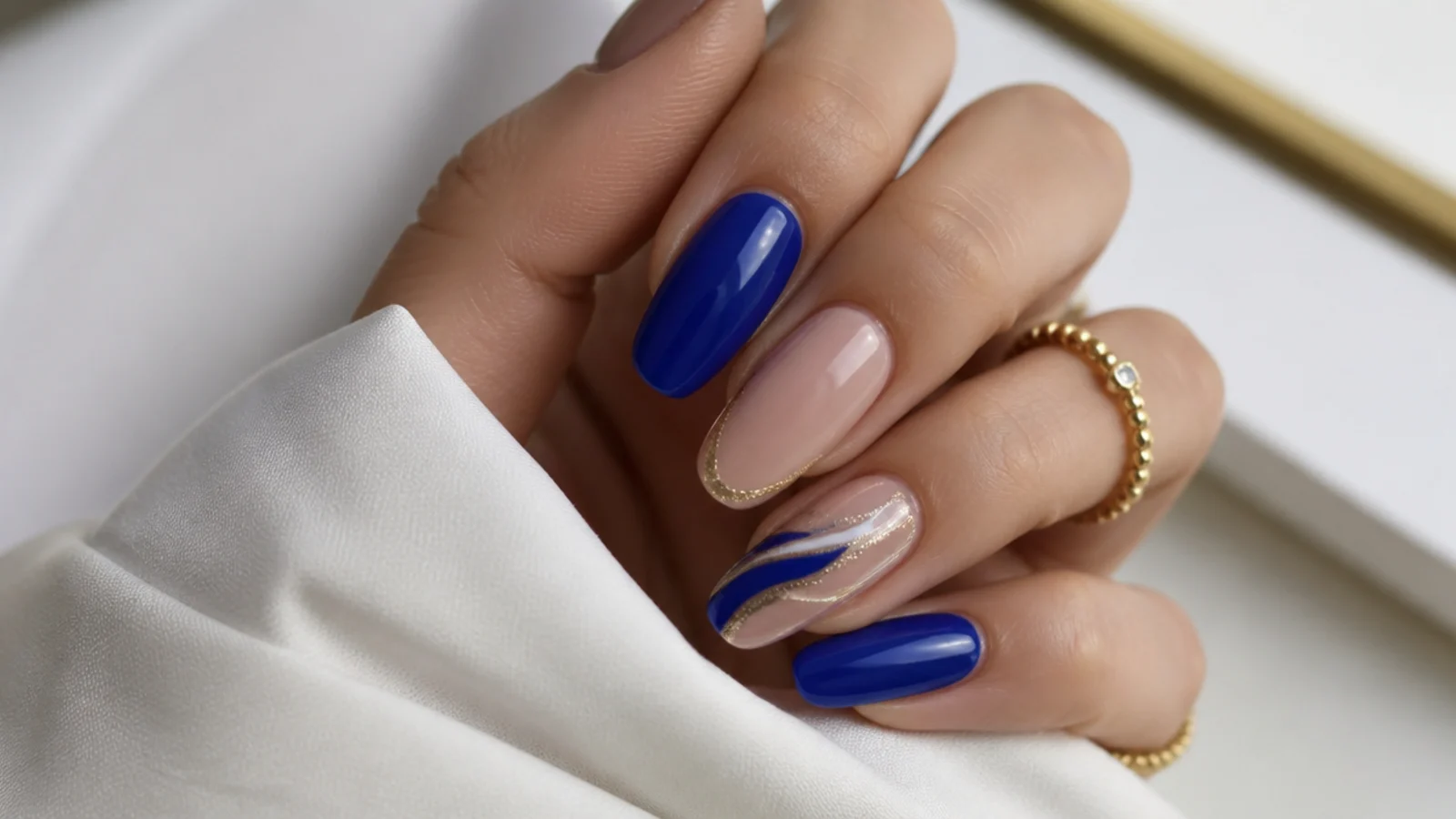 Royal blue nails shown paired with gold, silver, white and nude accents