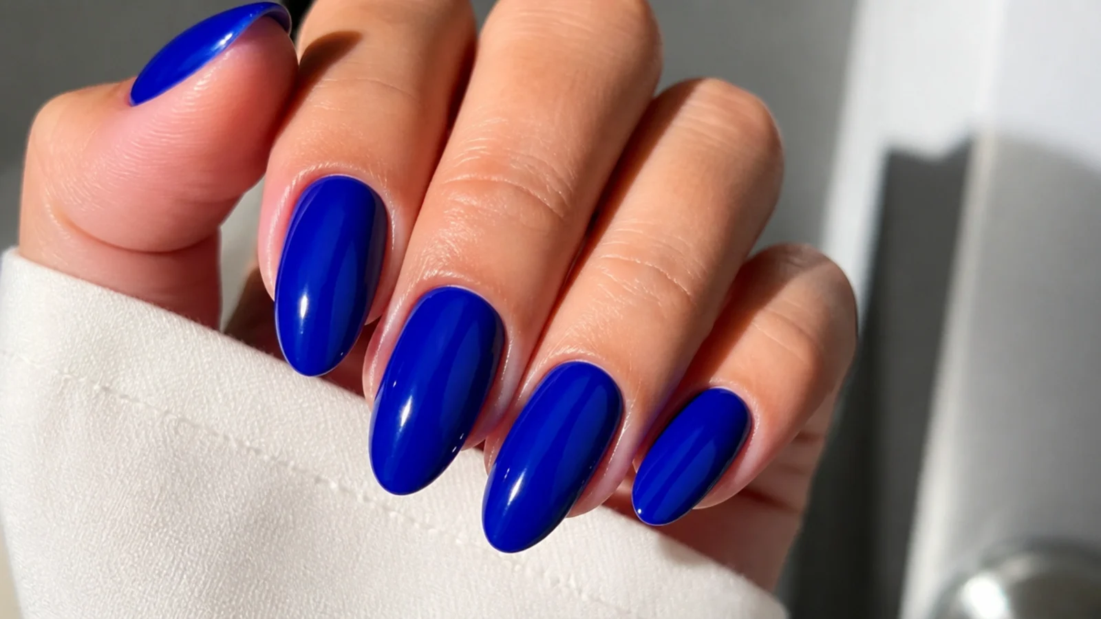 Almond nails in glossy true royal blue with a high-shine top coat