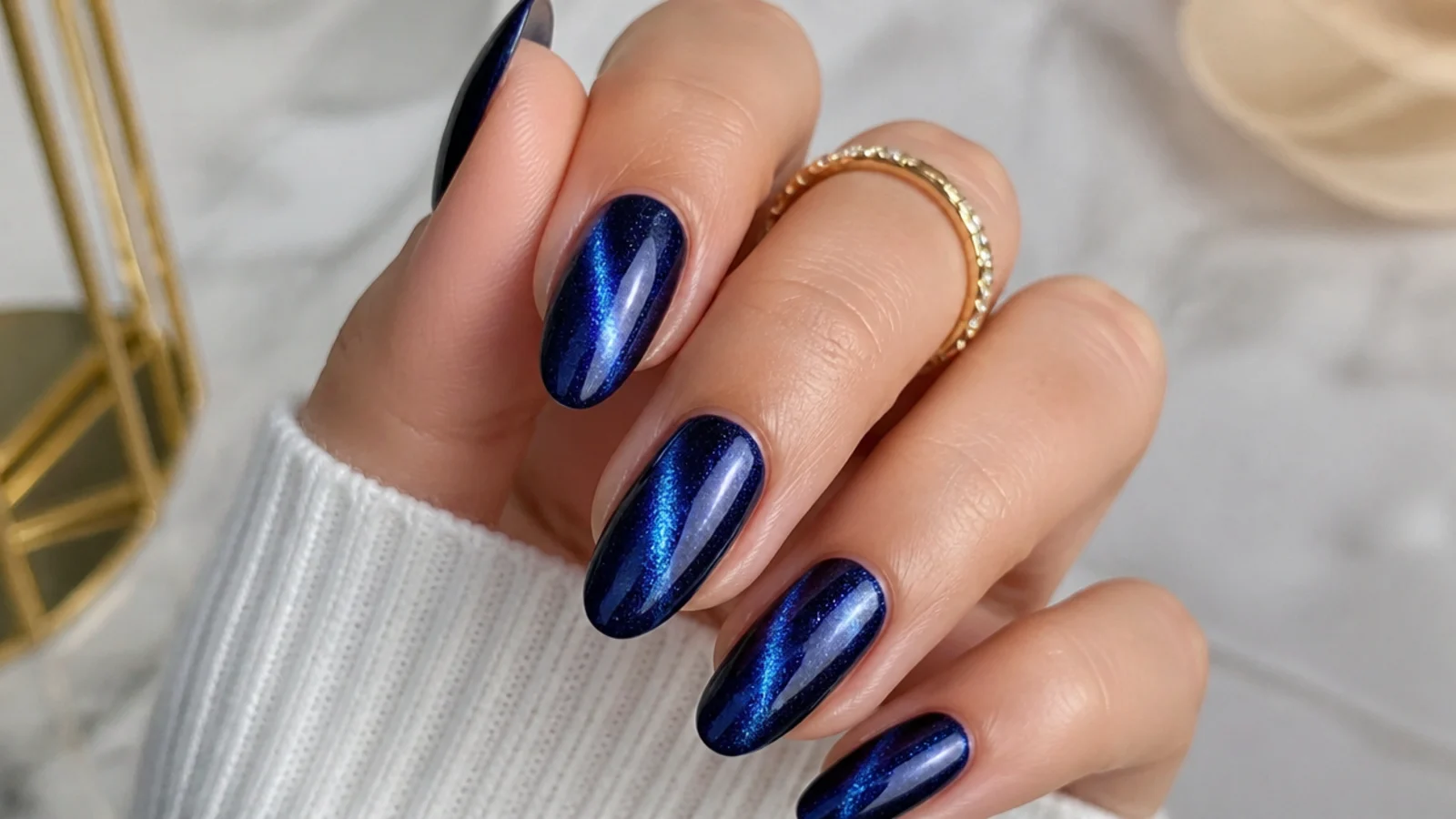 Almond nails in royal blue cat-eye gel with a bright magnetic light streak