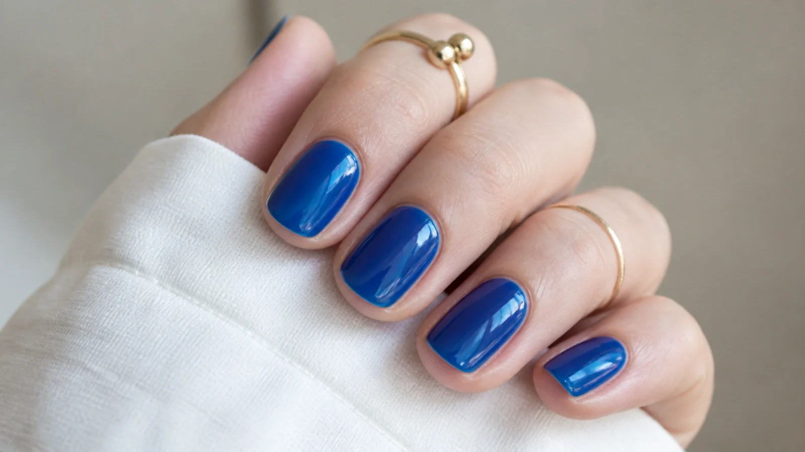Short round nails in a translucent jelly royal blue with a glassy shine
