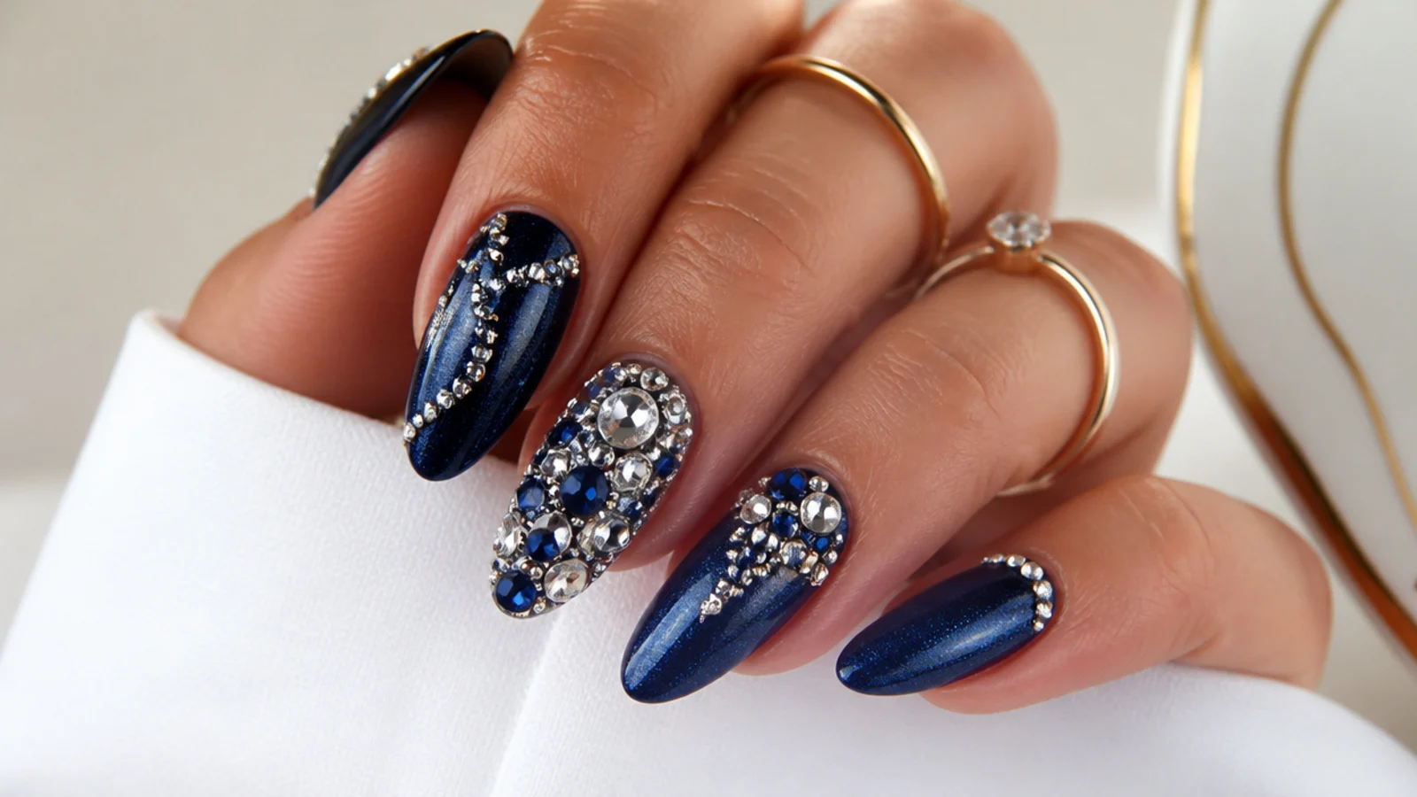 Almond nails in royal blue with dense crystal and silver rhinestone detailing
