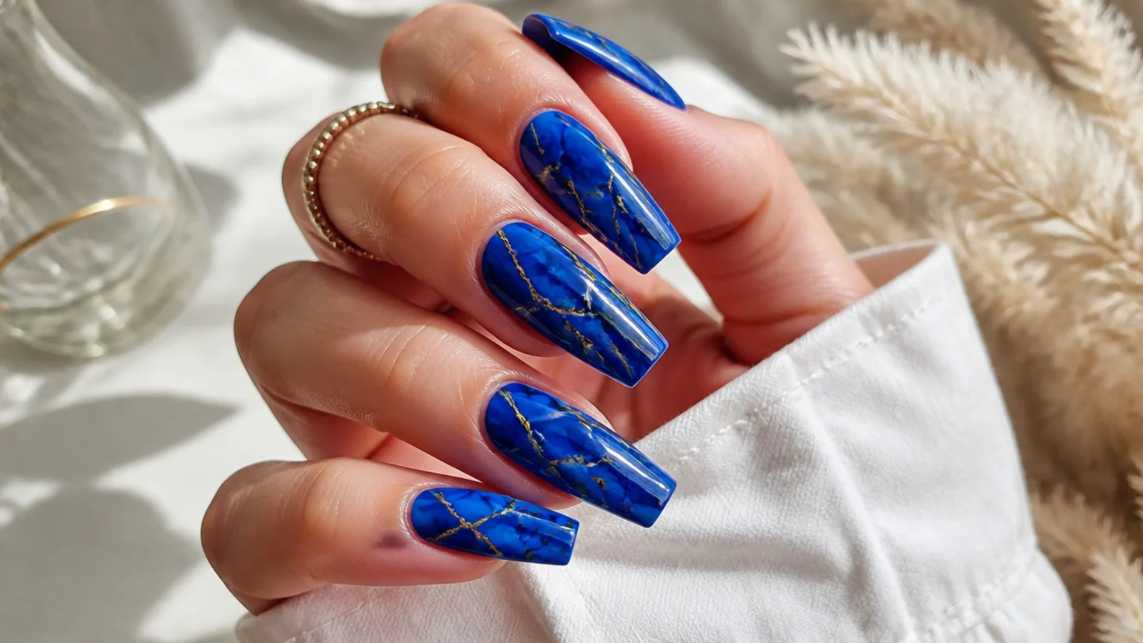 Coffin nails in royal blue with white marble veining and thin gold foil lines