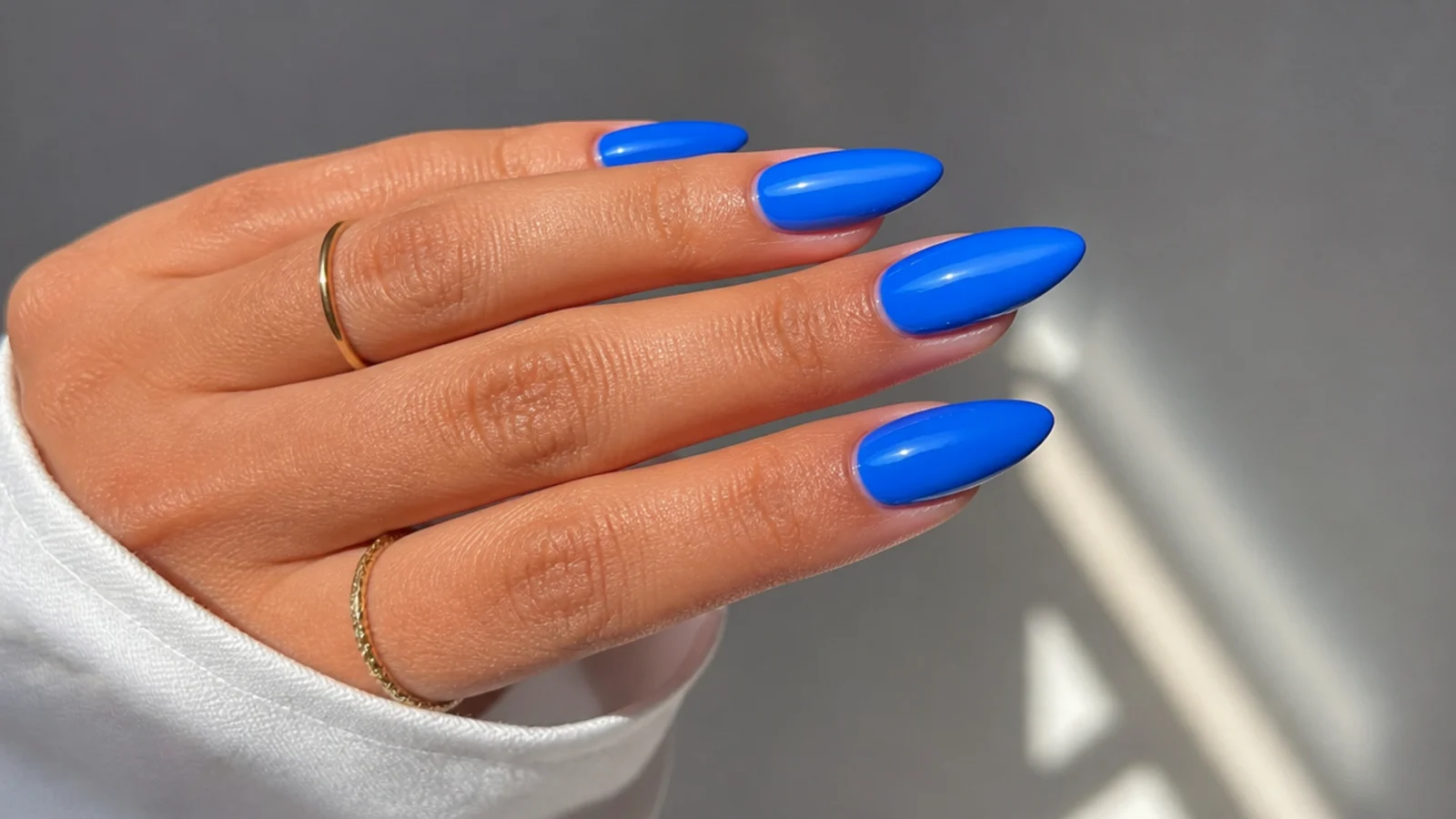 Almond nails in a bright, lighter royal blue with a cool glossy finish