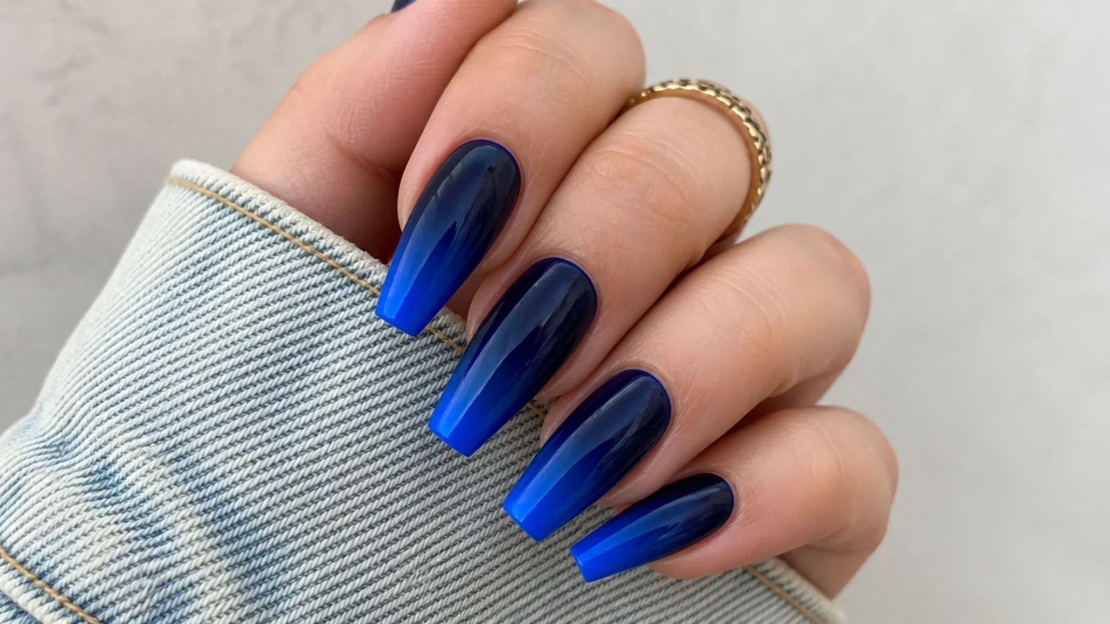 Coffin nails fading from deep navy at the cuticle into bright royal blue tips