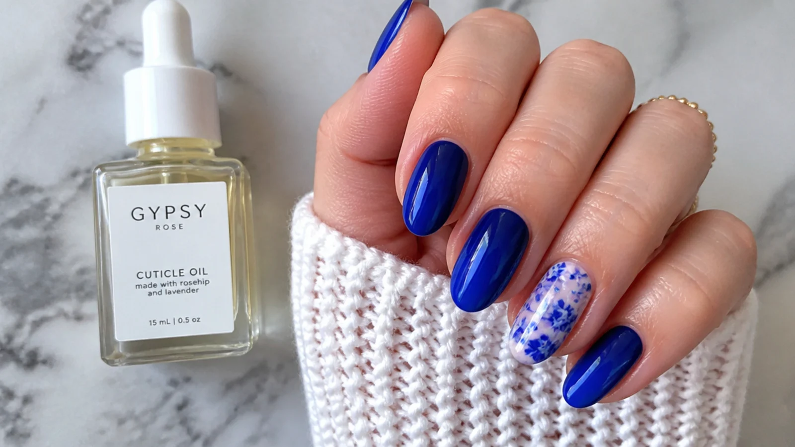 Cuticle oil beside a glossy royal blue gel manicure for longevity