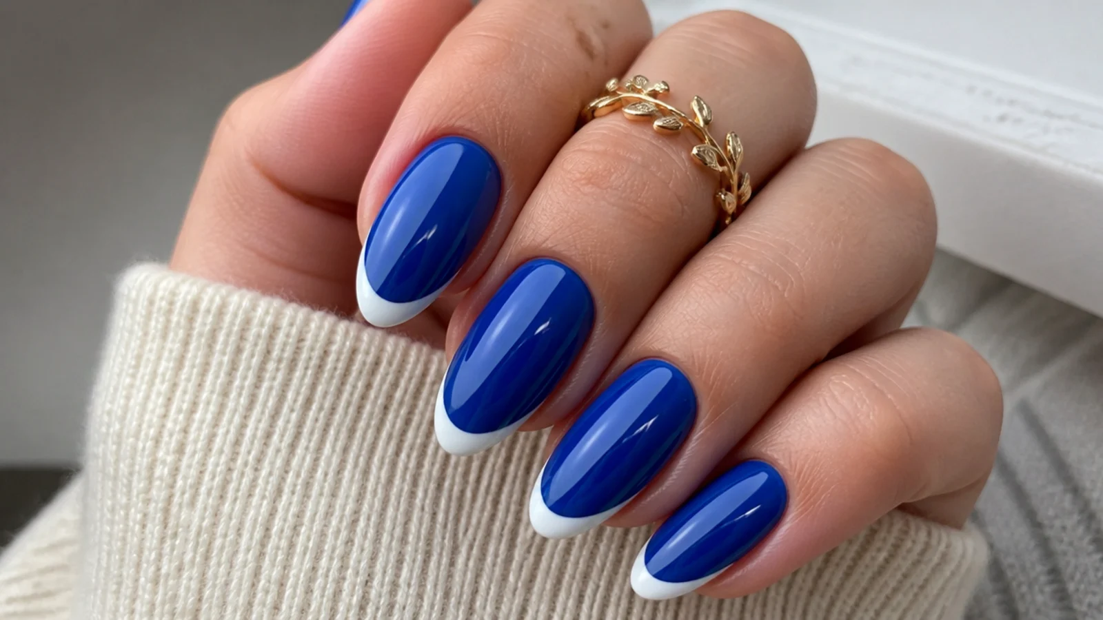 Royal blue nails with crisp white french tips on an almond shape