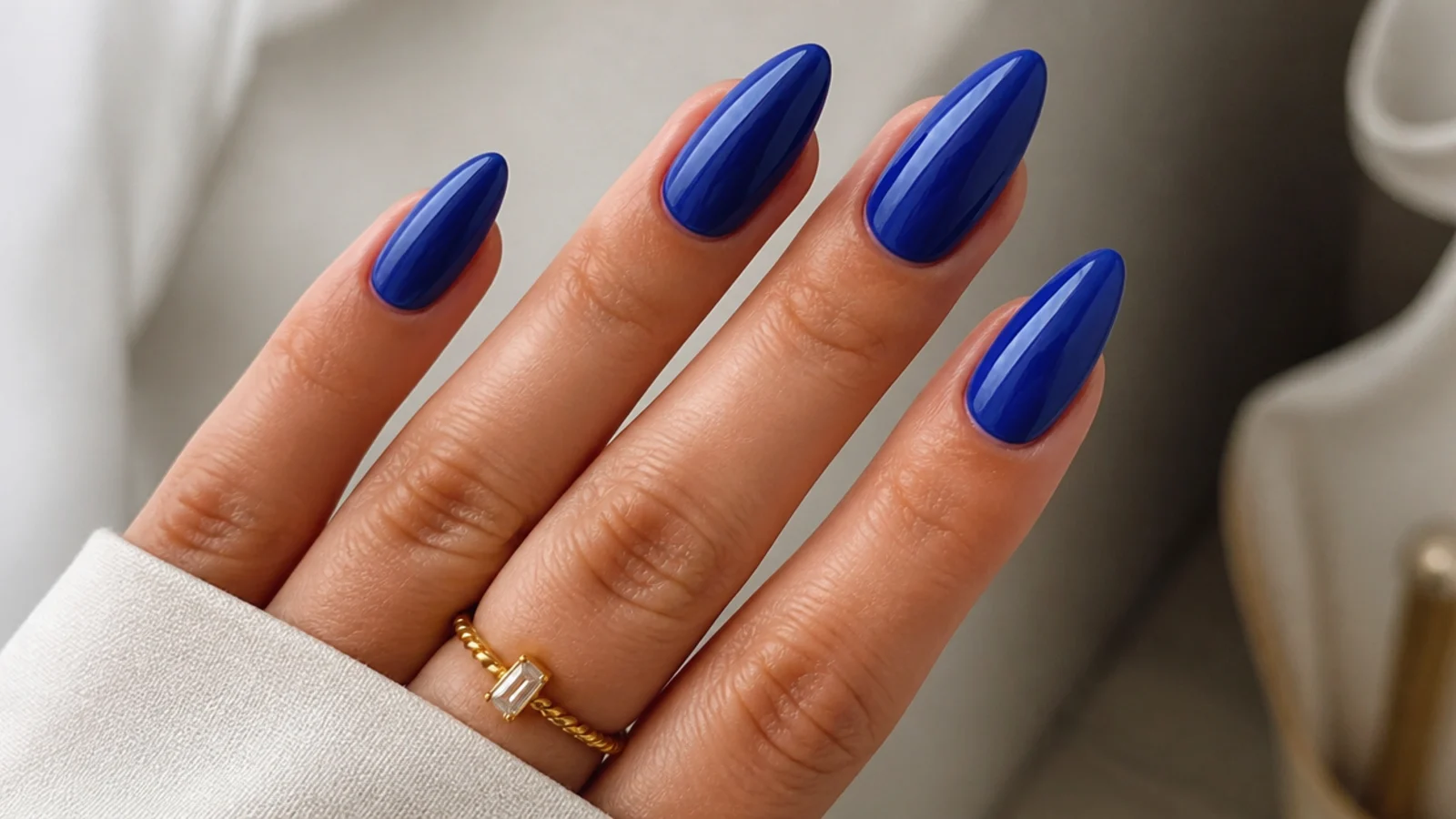 Glossy royal blue almond nails with a tapered elegant shape
