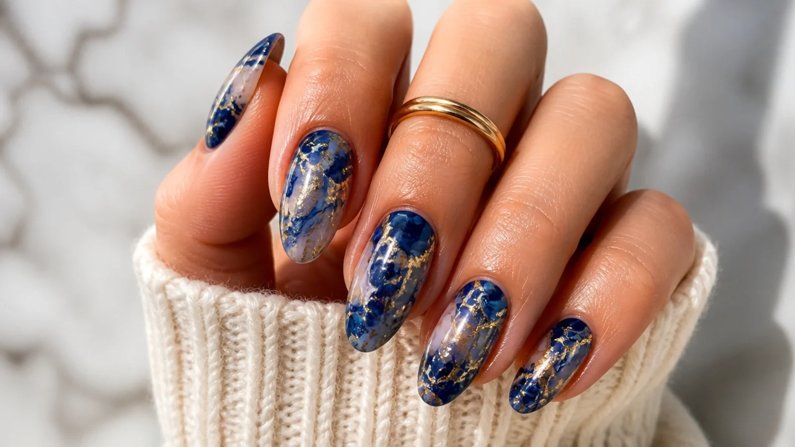 Royal blue and gold marble nails with veined metallic swirls
