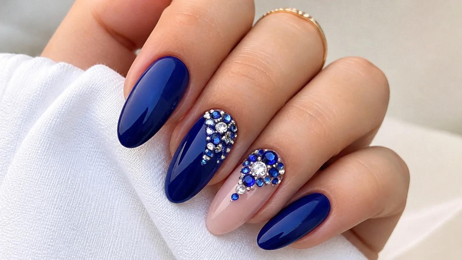 Royal blue nails with clustered clear and blue rhinestones on accents