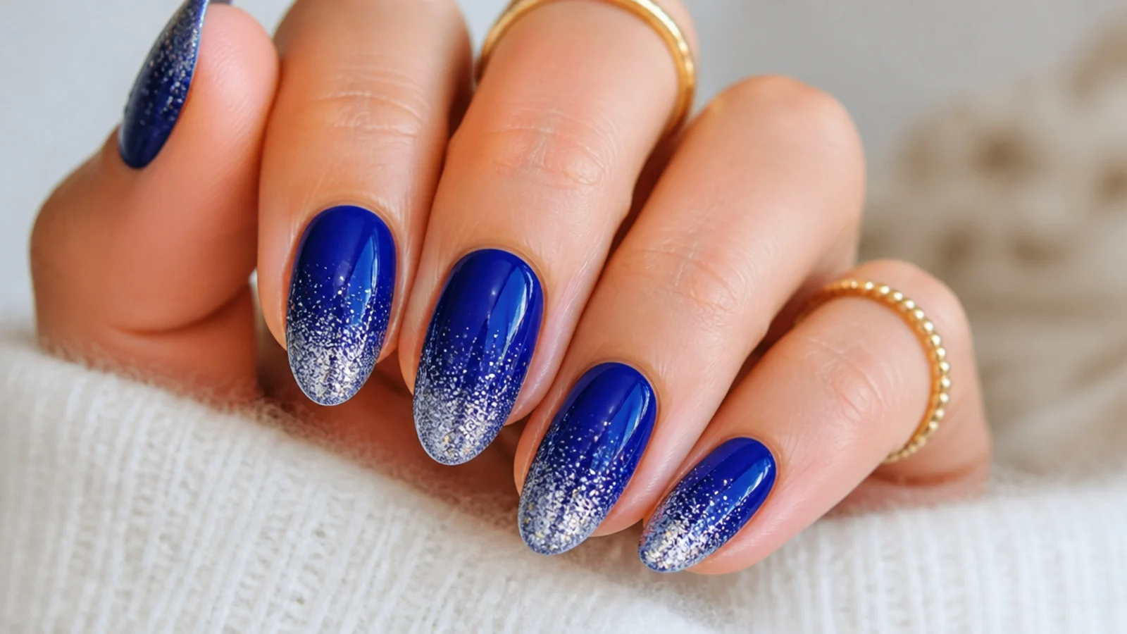 Royal blue nails fading into silver glitter at the tips