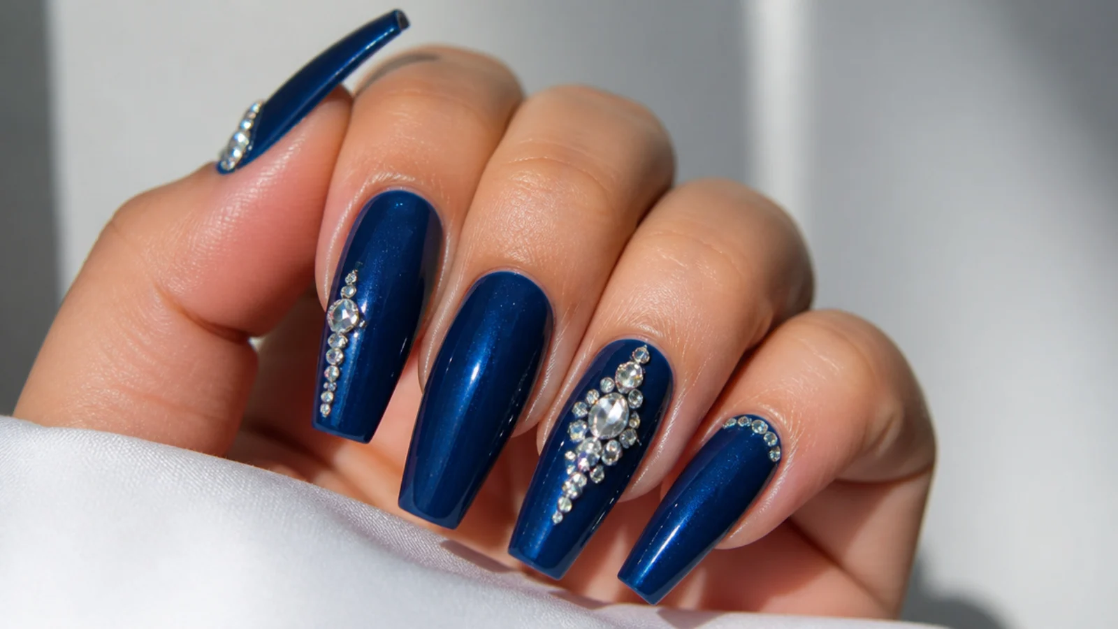 Long glossy royal blue prom nails with silver rhinestone accents