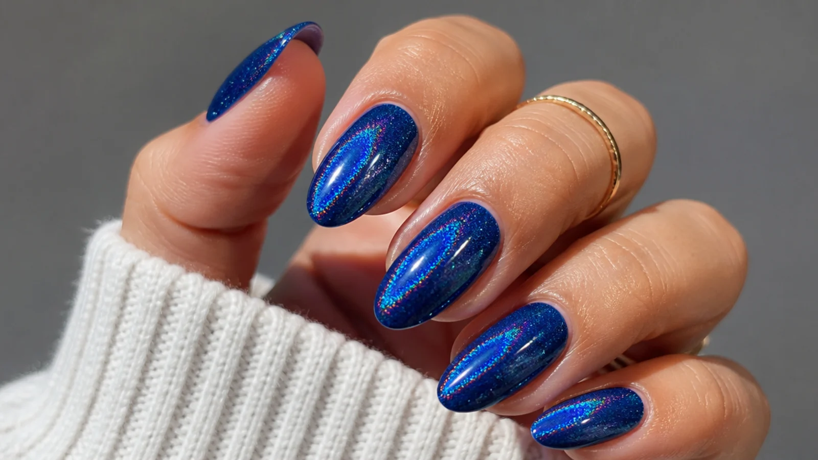 Royal blue holographic nails with a rainbow shimmer over deep blue