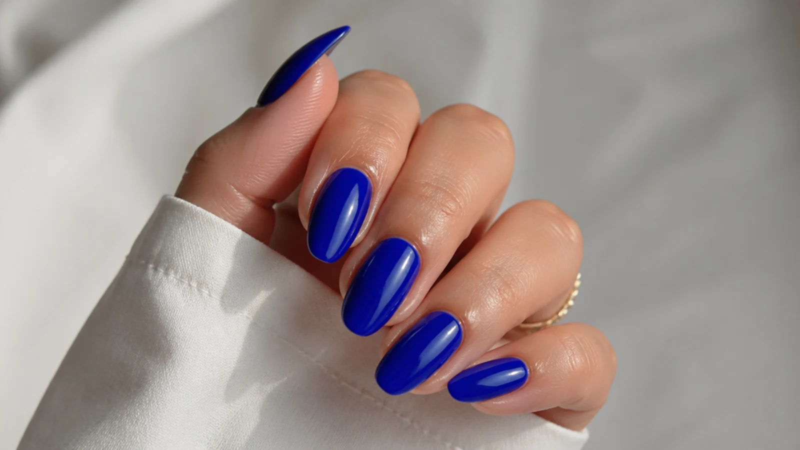 A sealed glossy royal blue manicure with cuticle oil for longevity