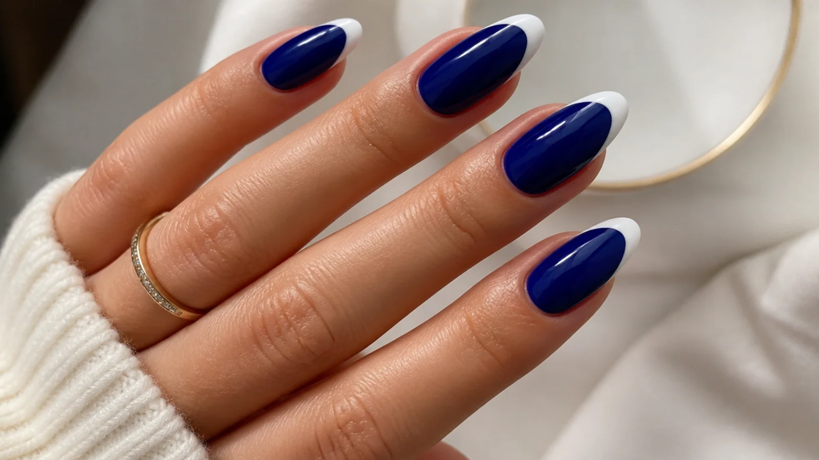Royal blue nails with a crisp white french tip on an almond shape