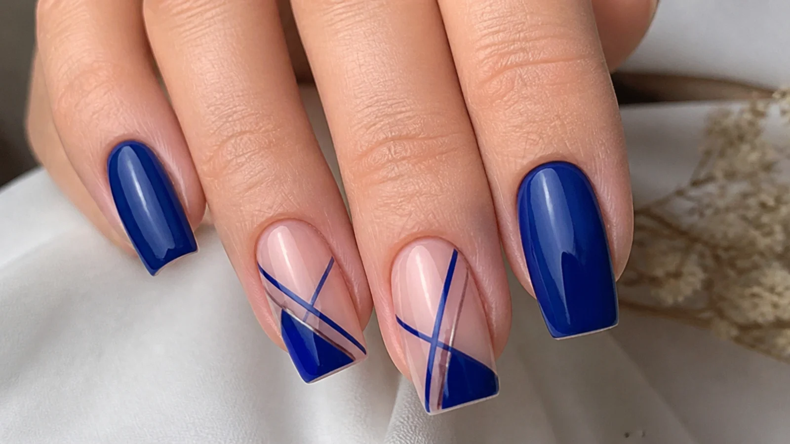 Royal blue nails with nude negative space and geometric lines