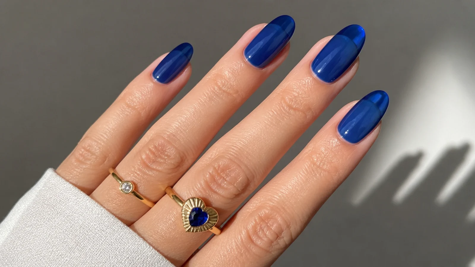 Sheer royal blue jelly nails with a translucent glassy finish