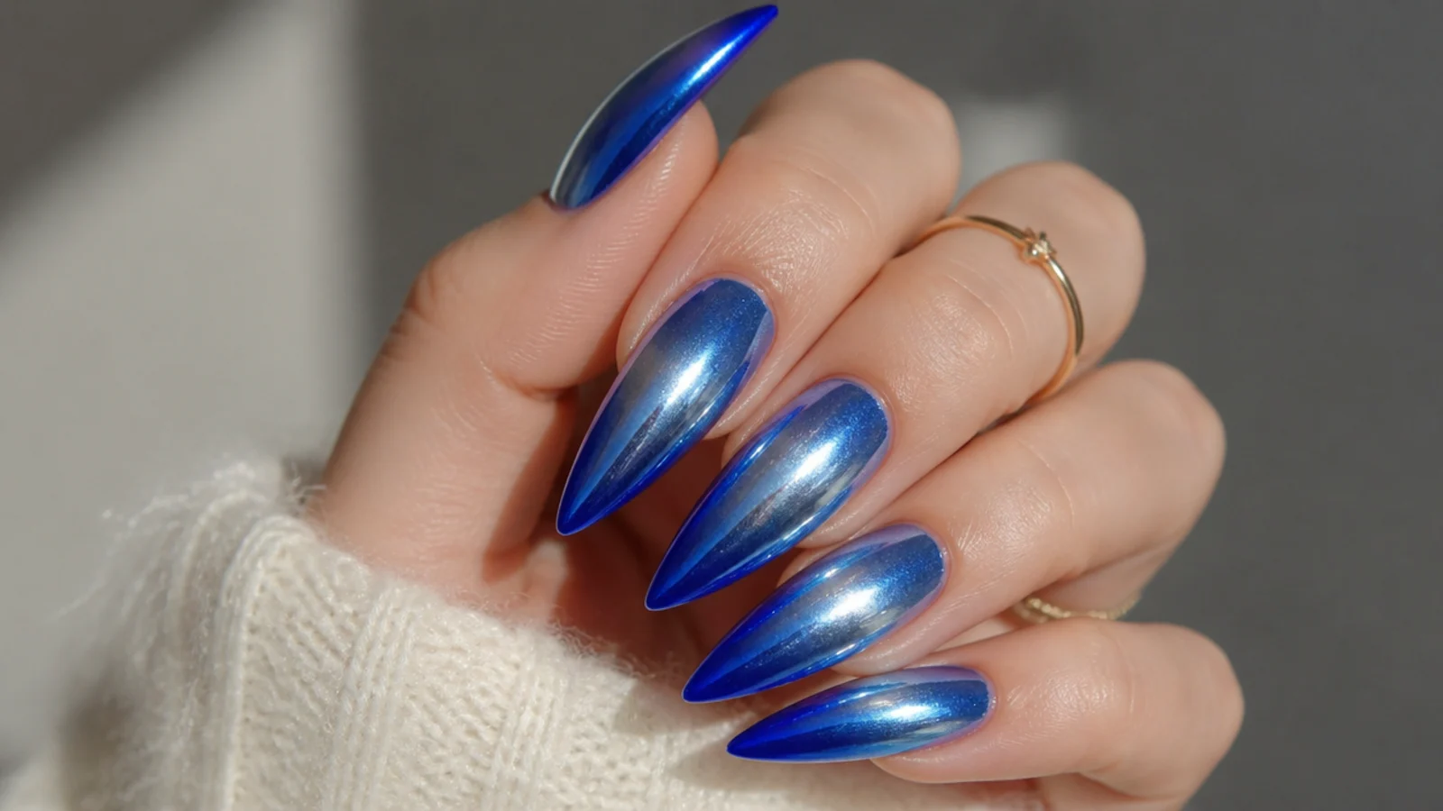 Sharp royal blue stiletto nails with a chrome ombre finish