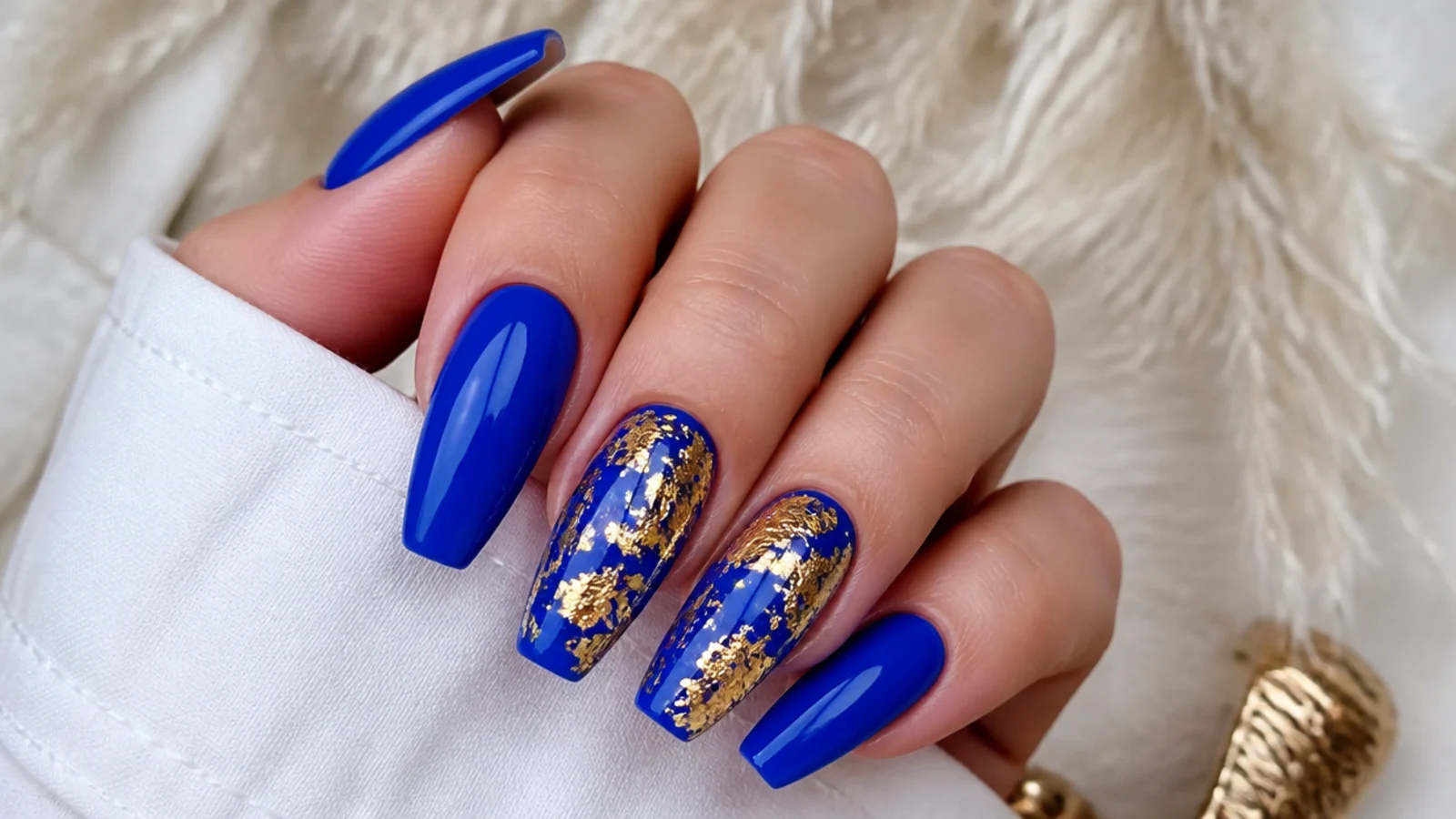 Glossy royal blue coffin nails with gold foil flakes on accent nails