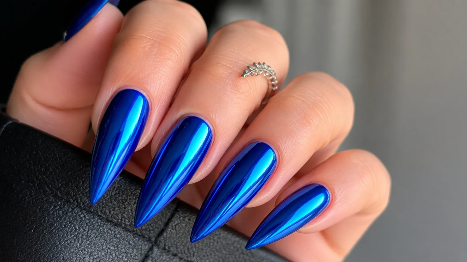 Mirror chrome royal blue stiletto nails with a reflective metallic finish