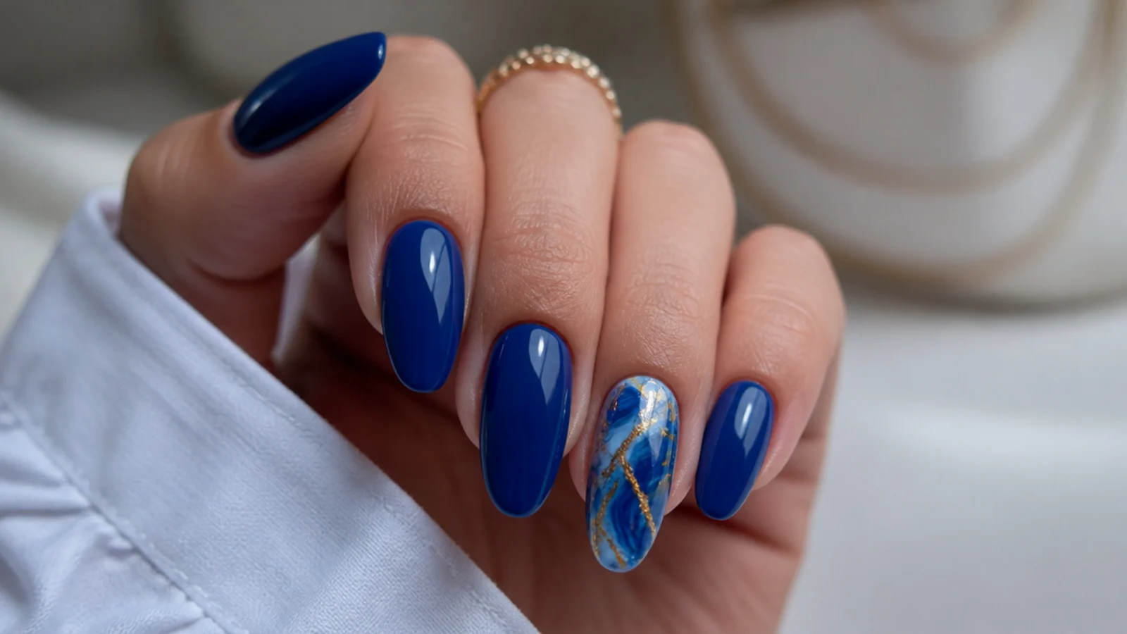 Royal blue nails with a blue and gold marble accent nail
