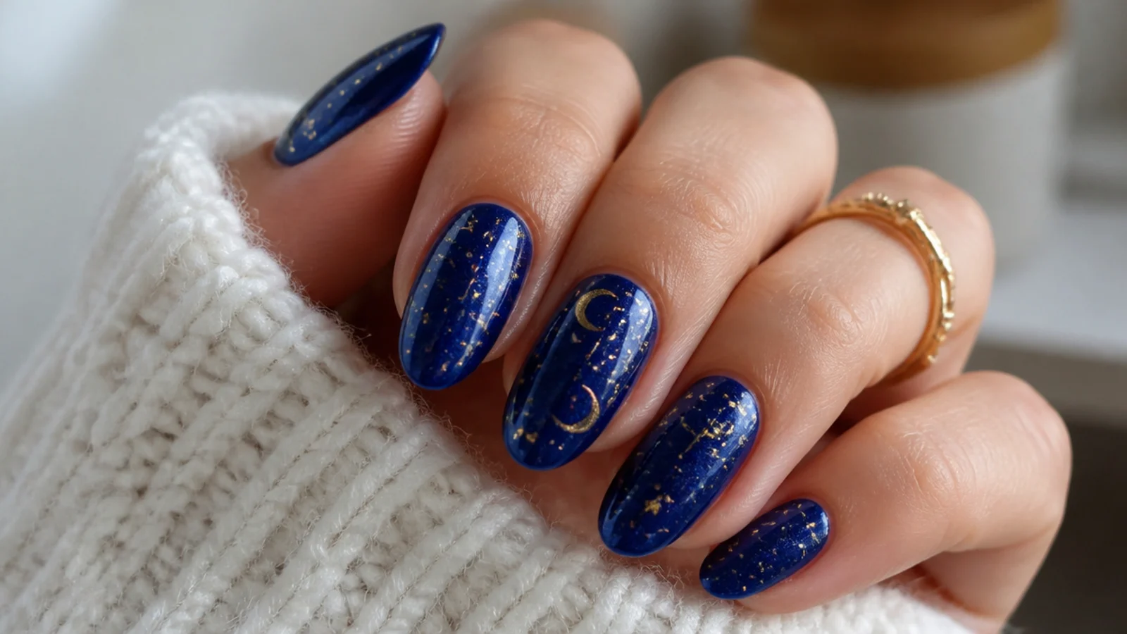 Royal blue nails with tiny gold stars and moons on a night-sky base