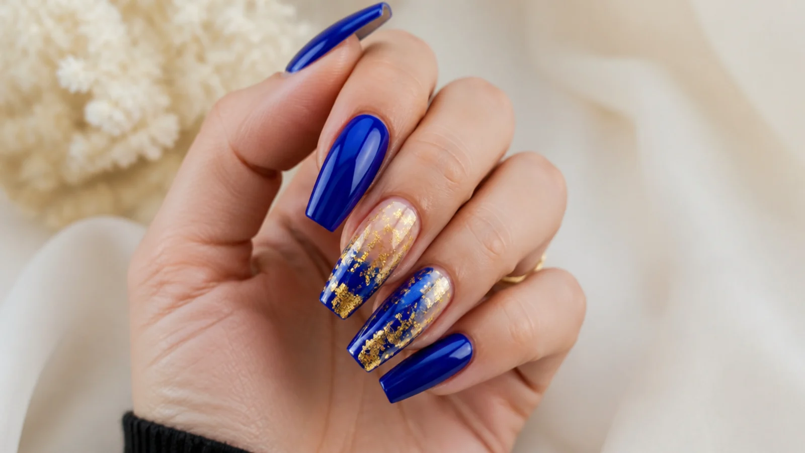 Bold royal blue quince nails with gold accents on a coffin shape