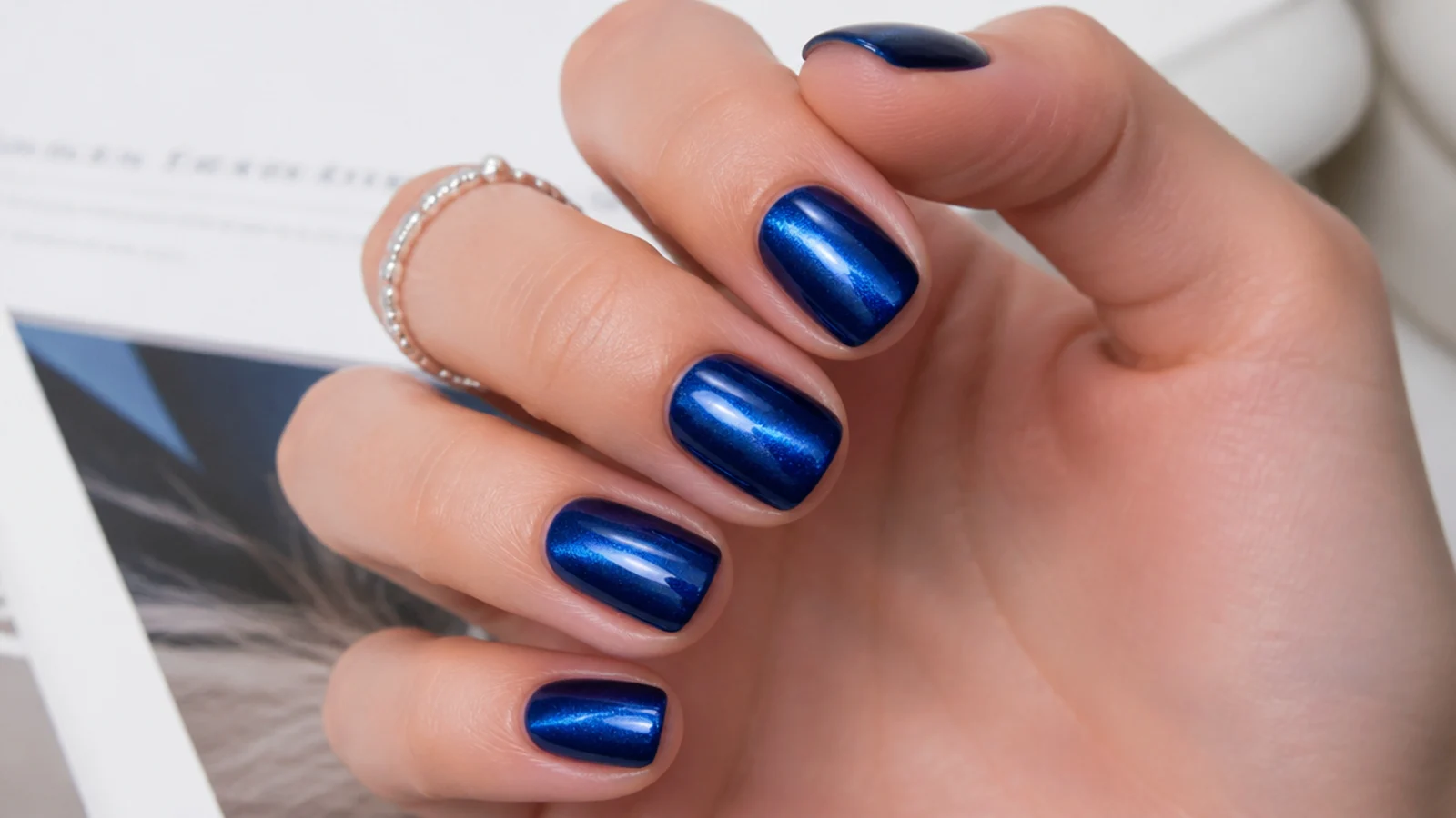 Short royal blue cat-eye nails with a bright magnetic light stripe