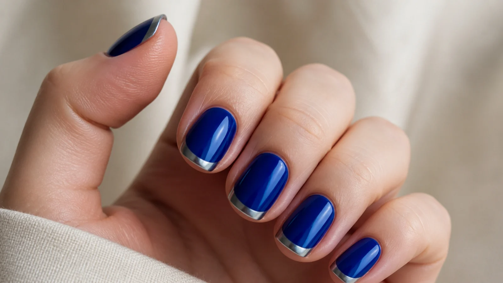 Short royal blue nails with a cool silver chrome accent tip