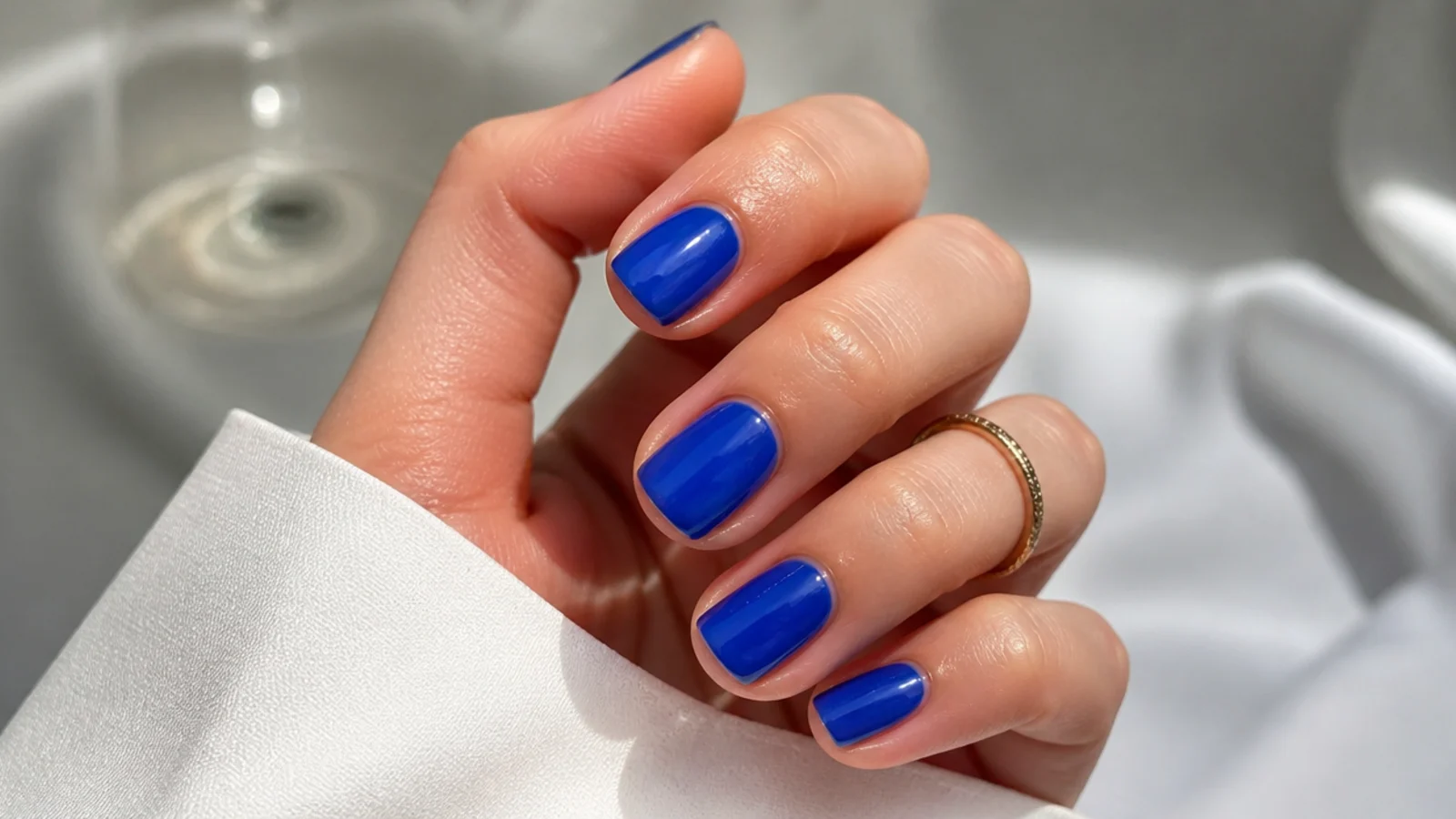 Short royal blue jelly nails with a translucent glassy finish