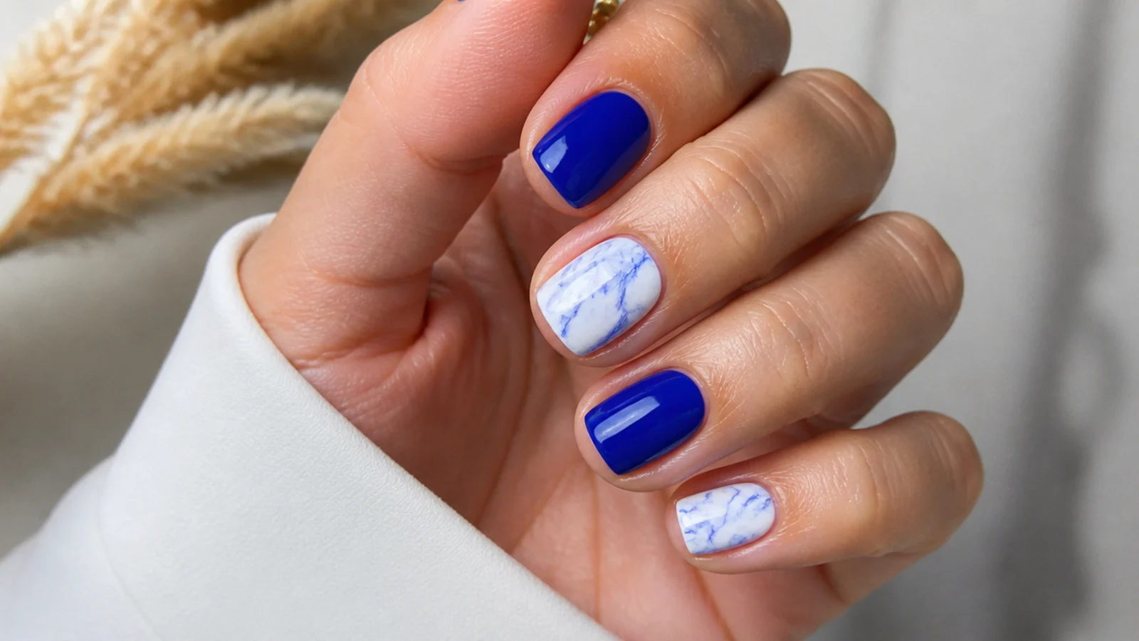 Short royal blue and white marble nails with soft swirled veins