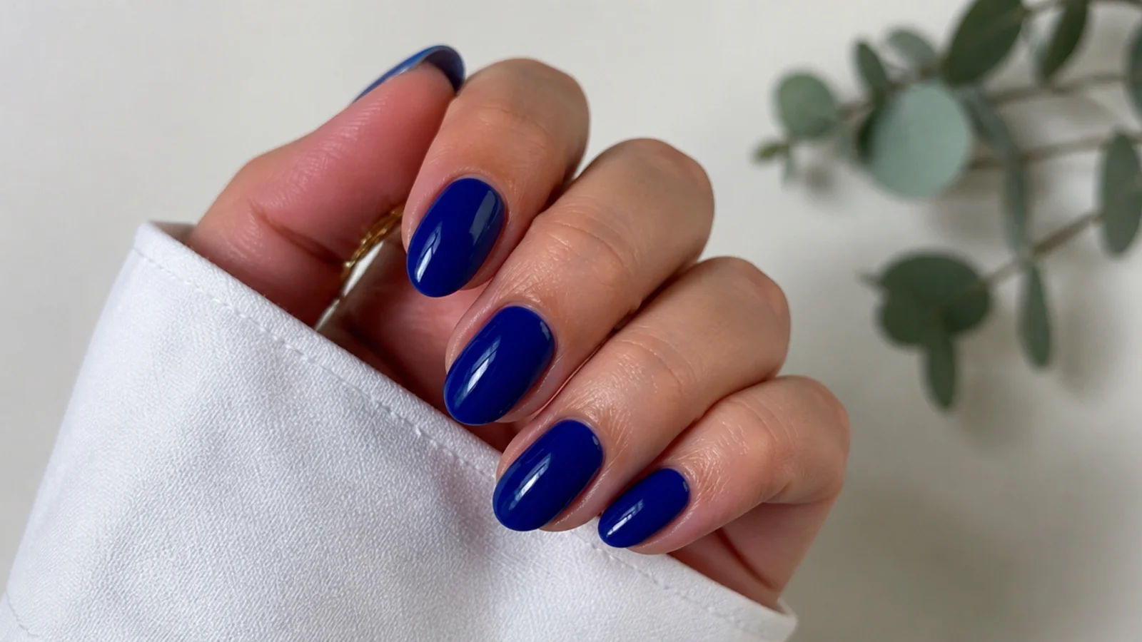 Short almond-shaped nails in a deep glossy royal blue