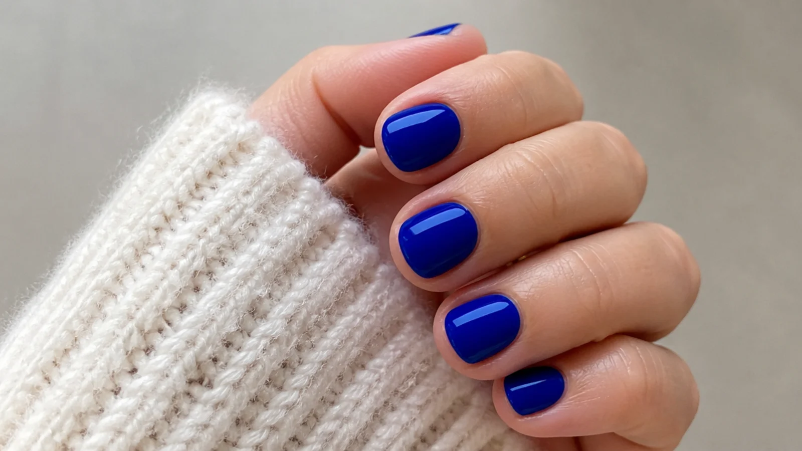 Very short round nails in an even glossy royal blue
