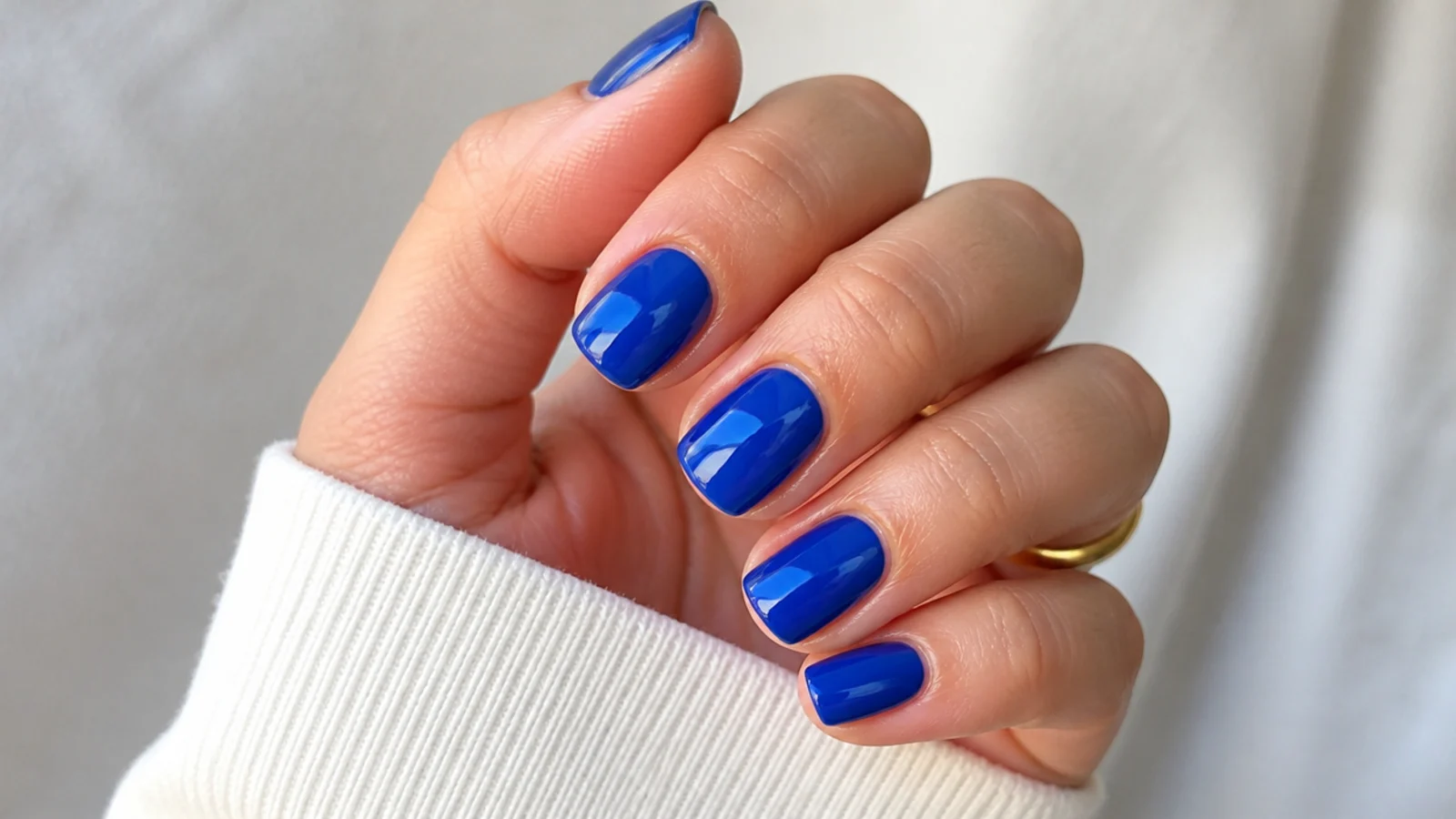 A well-sealed short royal blue gel manicure with cuticle oil