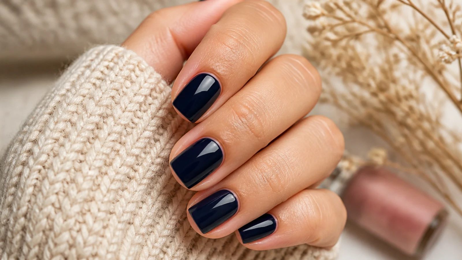 Short square nails on light medium skin in a deep glossy navy blue cream polish