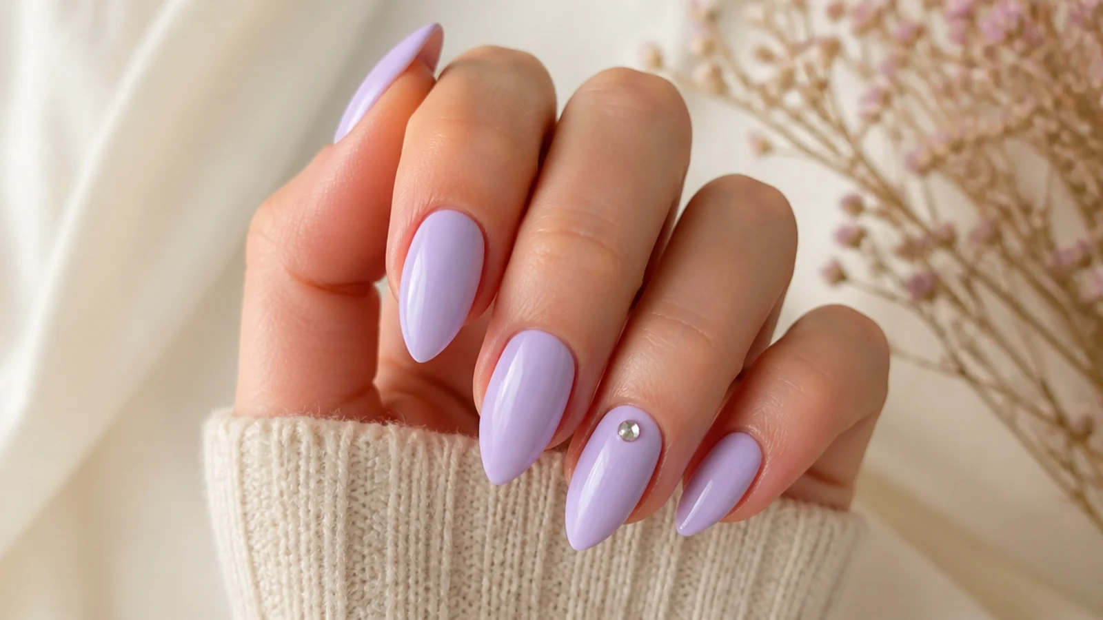 Short stiletto nails in soft lilac with pointed tips and a silver rhinestone on one accent nail