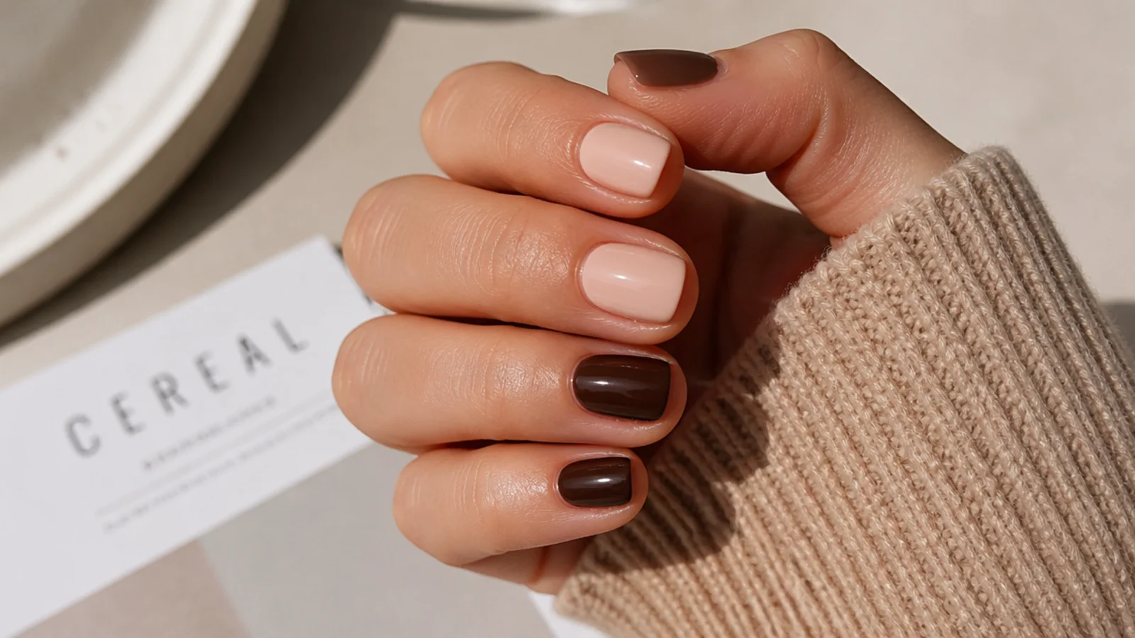 Short nails compared side by side in skin matched nude and deep espresso brown