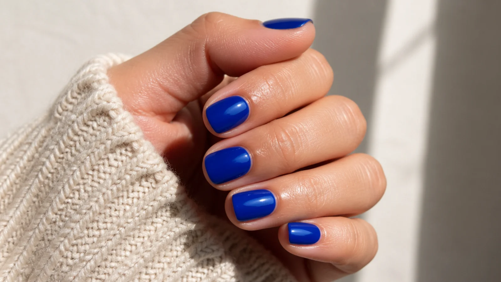 Short nails in electric cobalt blue cream polish with a deep glossy finish