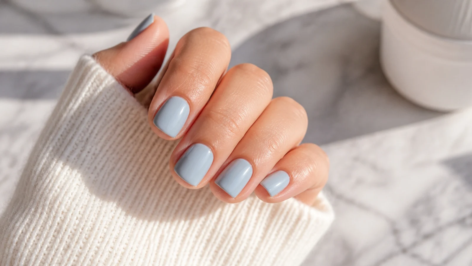 Short nails in dusty foggy sky blue cream polish with a soft opaque finish