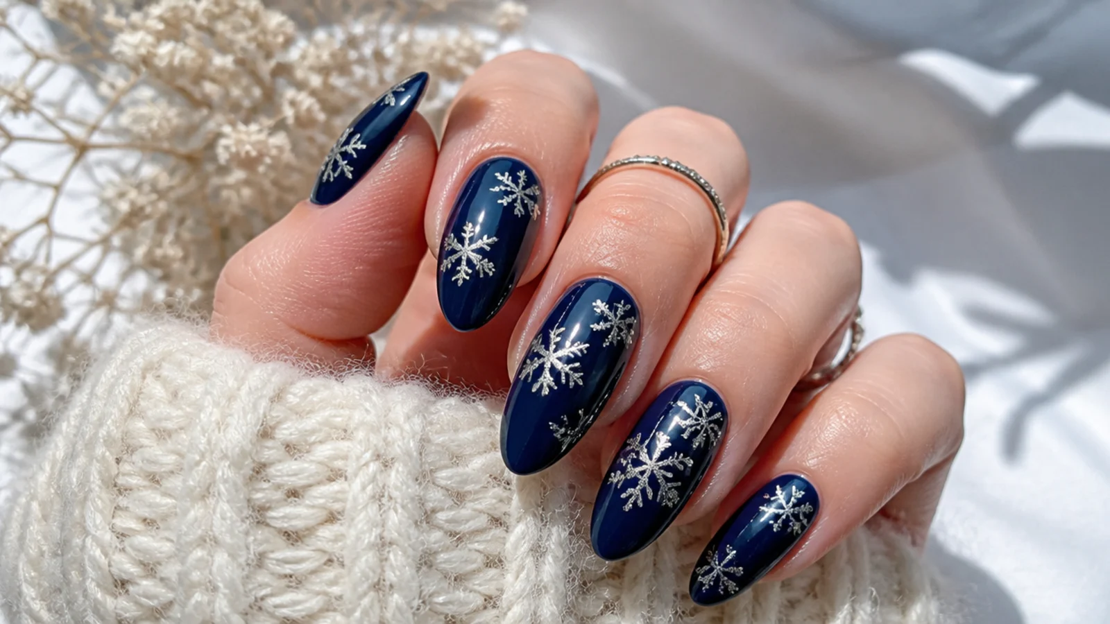 Deep navy nails with silver chrome snowflakes and a mirror sheen