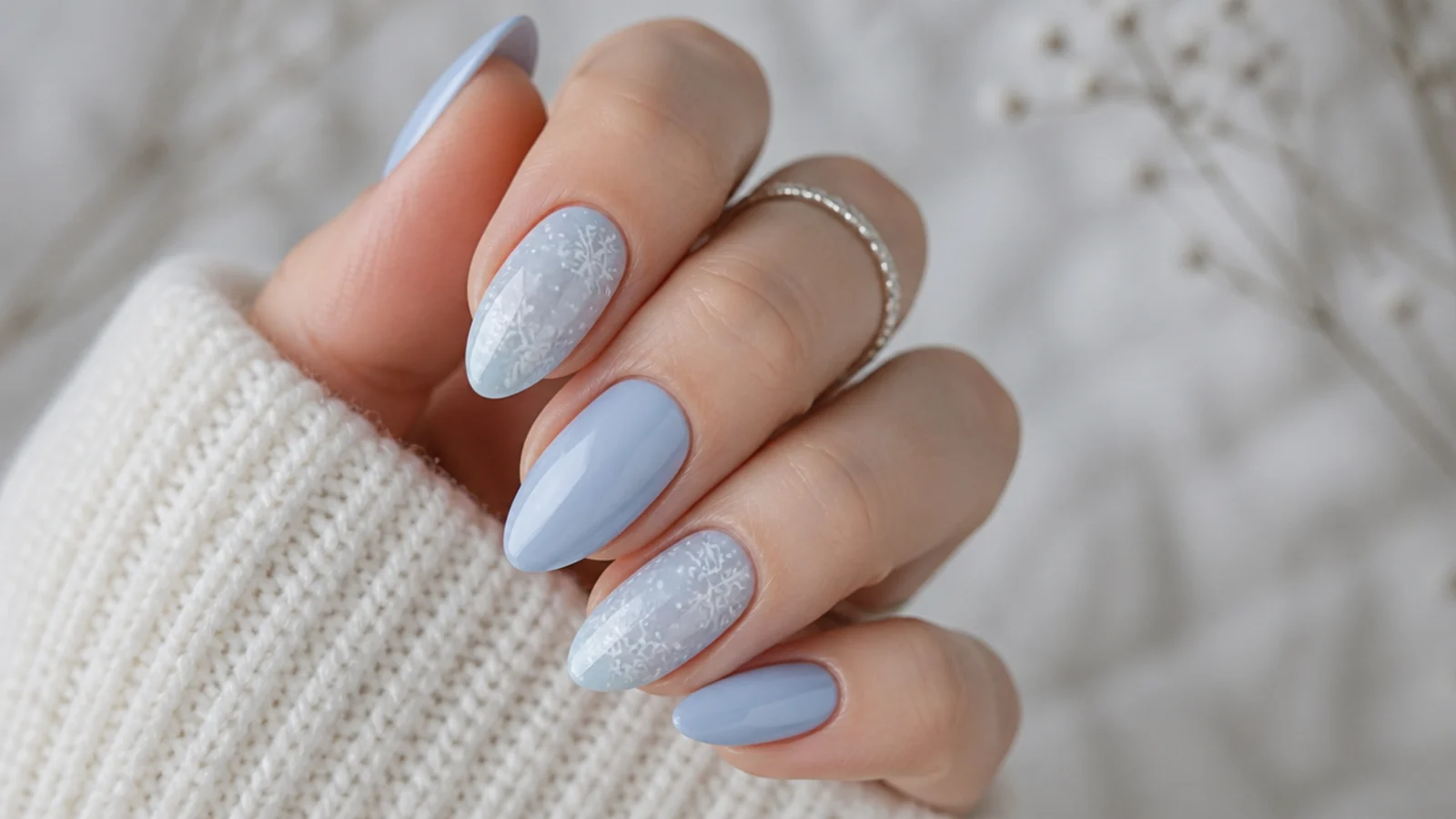 Soft pastel blue nails with white snowflakes and a gentle finish