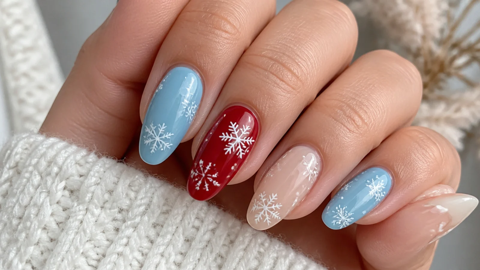 Icy blue, red and nude snowflake nails shown side by side