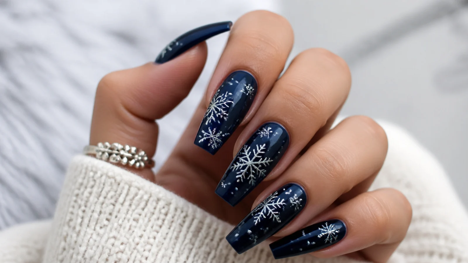 Silver snowflakes over a deep navy base on coffin winter nails