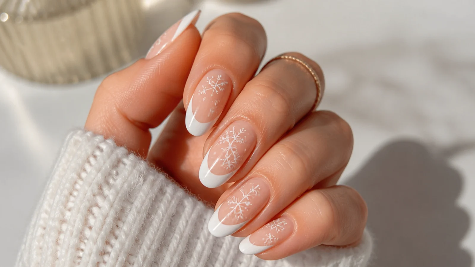 White French tips with small white snowflakes on a nude base
