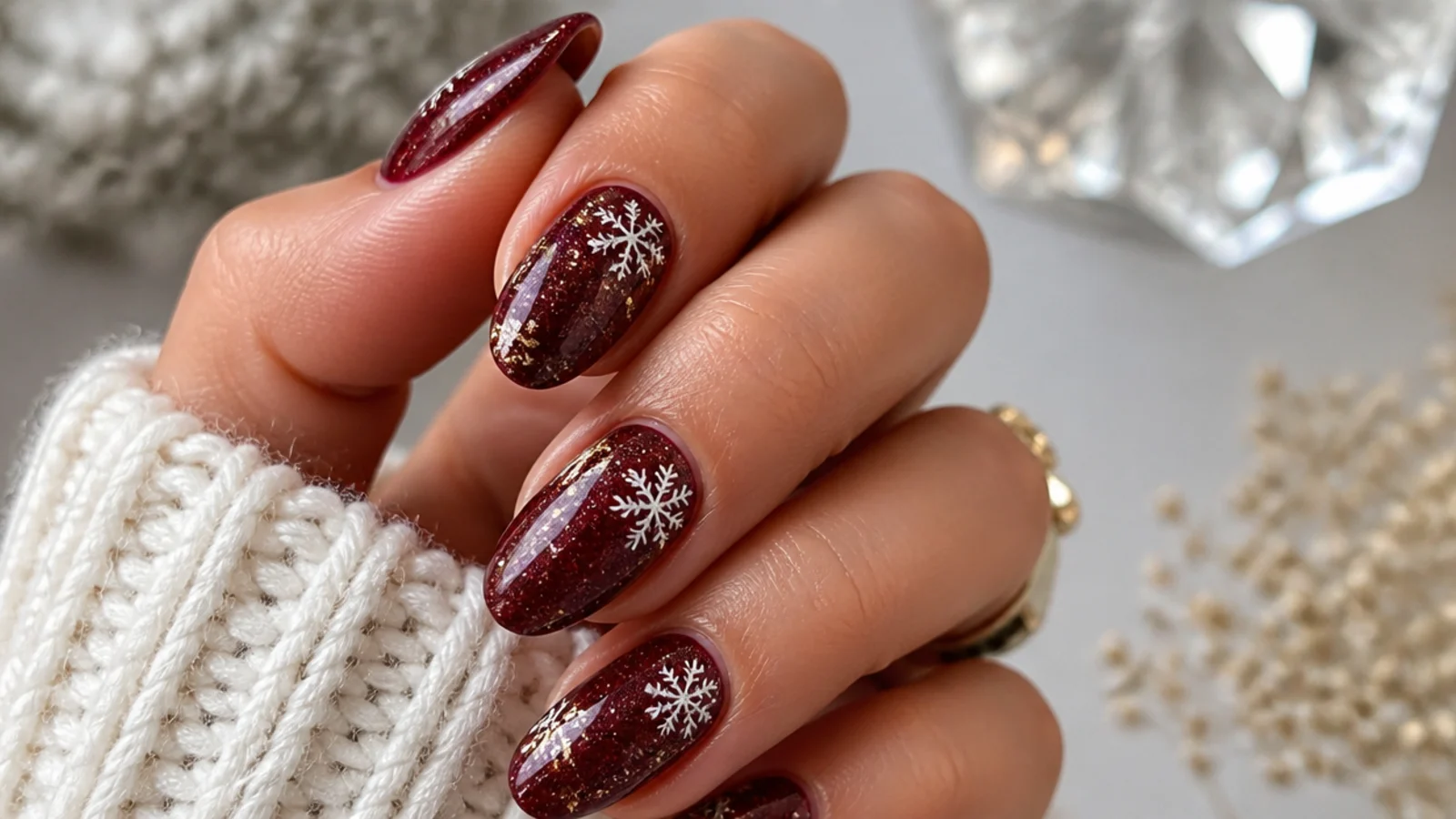 Burgundy glitter snowflake nails with gold flakes and sparkle