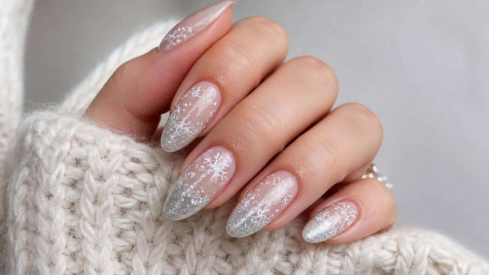 Silver glitter ombre nails with white snowflakes over an icy base