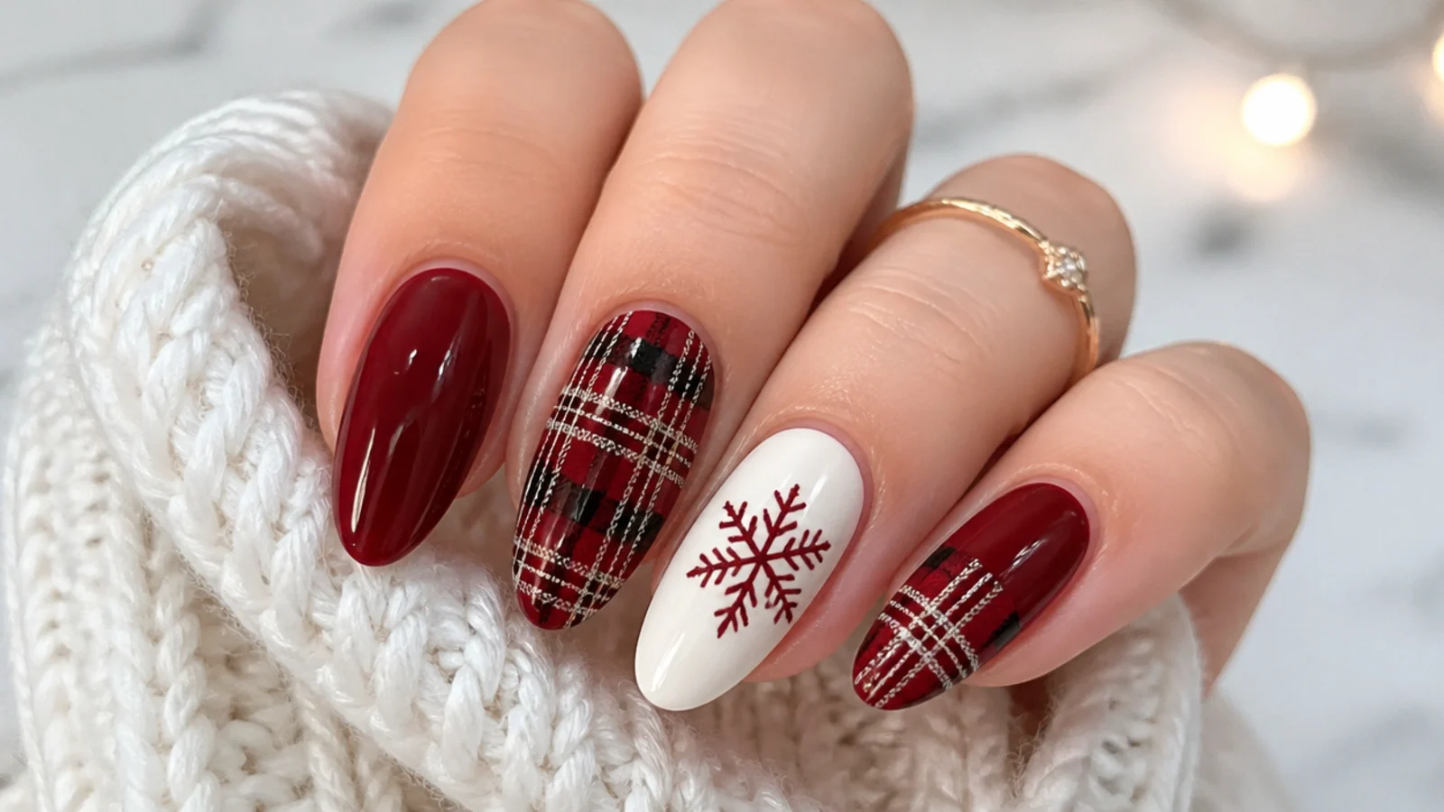 Red nails mixing tartan plaid nails with white snowflake accent nails